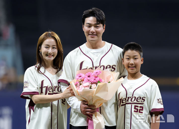[서울=뉴시스] 홍효식 기자 = 박병호 키움 히어로즈 코치가 26일 서울 구로구 고척스카이돔에서 열린 2026 KBO 리그 삼성 라이온즈와 키움 히어로즈의 경기 전 은퇴식에서 아내 이지윤 전 아나운서에게 꽃다발을 전달받은 뒤 아들과 함께 기념촬영하고 있다. 2026.04.26. yesphoto@newsis.com