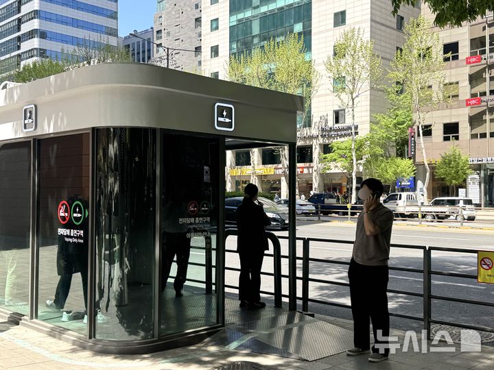 [서울=뉴시스] 김세은 인턴기자 = 24일 서울 강남구 테헤란로 금연거리에 위치한 흡연부스에서 담배를 피우고 있는 흡연자들의 모습. 2026.04.24.