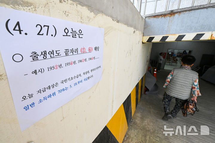 [광주=뉴시스] 이영주 기자 = 정부의 고유가 피해지원금 1차 신청·지급이 시작된 27일 오전 광주 북구 오치1동주민센터에서 한 시민이 피해지원금 신청을 하기 위해 이동하고 있다. 2026.04.27. leeyj2578@newsis.com