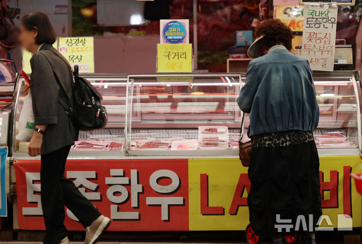 [서울=뉴시스] 조성우 기자 = 고유가 피해지원금 1차 지급이 시작된 27일 서울 강서구 남부골목시장 정육점에서 한 시민이 고기를 구매하고 있다. 2026.04.27. xconfind@newsis.com