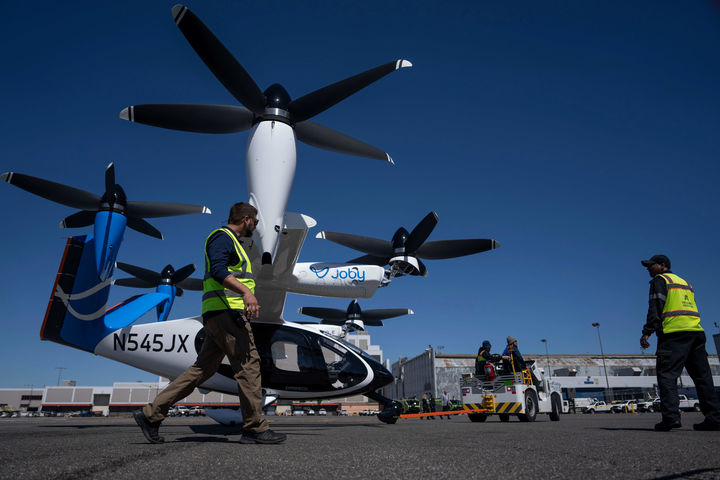 [뉴욕=AP/뉴시스] 27일(현지 시간) 미국 뉴욕 존 F. 케네디 국제공항에서 공항 관계자들이 '조비 에비에이션'의 전기 수직이착륙기(eVTOL)를 이동시키고 있다. 조비 에비에이션은 '하늘을 나는 택시'로 불리는 eVTOL의 실제 비행경로와 환경에서의 운항을 검증하는, 열흘간의 시범 비행에 나섰다. 2026.04.28.