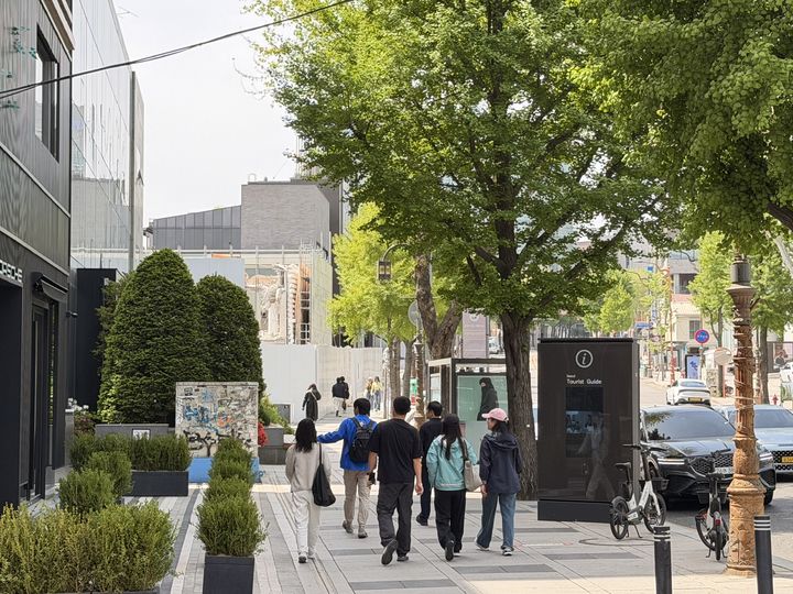 [서울=뉴시스] 유지담 인턴기자 = 한남동 카페거리 대로변에 위치한 '포르쉐 스튜디오 한남' 앞을 지나가는 사람들. *재판매 및 DB 금지
