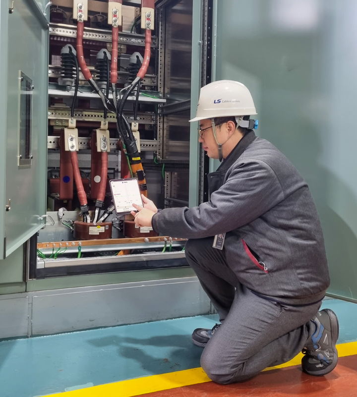  LS전선 작업자가 모바일 기기에 설치된 아이체크 시스템 애플리케이션을 통해 배전 케이블의 상태를 실시간으로 모니터링 하고 있다.(사진제공=LS전선) *재판매 및 DB 금지