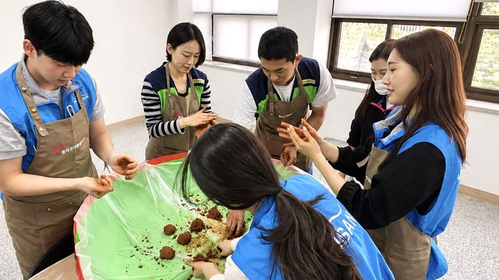 [부산=뉴시스] 지난 27일 동래구자원봉사센터에서 에어부산·진에어 객실승무원들이 지역 사회 환경 개선을 위한 'EM 흙공 만들기' 봉사활동에 참여하고 있다. (사진=에어부산 제공) 2026.04.28. photo@newsis.com *재판매 및 DB 금지
