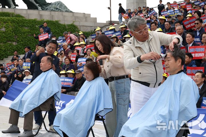 [서울=뉴시스] 조성봉 기자 = 김종기(앞줄 오른쪽부터) 부마민주항쟁기념재단 상임이사, 오월어머니집 추혜성 씨, 강응원 5.18 민주화운동부상자회 이사가 28일 오후 서울 여의도 국회 본청 계단 앞에서 열린 '부마항쟁 및 5.18정신 헌법전문 수록 개헌촉구 결의대회'에서 삭발을 하고 있다. 2026.04.28. suncho21@newsis.com