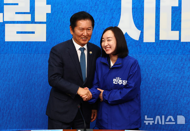 [서울=뉴시스] 김명년 기자 = 전은수 전 청와대 대변인이 29일 오전 서울 여의도 국회에서 열린 더불어민주당 인재영입식에서 정청래 대표에게 당 점퍼를 전달받은 뒤 기념촬영하고 있다. 2026.04.29. kmn@newsis.com