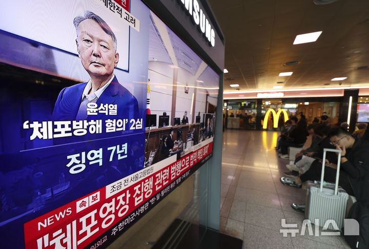 [서울=뉴시스] 조성우 기자 = 29일 오후 서울 중구 서울역 대합실에서 시민들이 체포 방해 및 국무위원 심의권 침해 혐의로 기소된 윤석열 전 대통령에 대한 2심 선고 공판 생중계를 보고 있다. 2026.04.29. xconfind@newsis.com