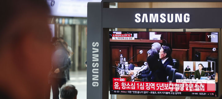 [서울=뉴시스] 조성우 기자 = 29일 오후 서울 중구 서울역 대합실에서 시민들이 체포 방해 및 국무위원 심의권 침해 혐의로 기소된 윤석열 전 대통령에 대한 2심 선고 공판 생중계를 보고 있다. 2026.04.29. xconfind@newsis.com