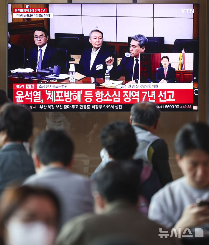 [서울=뉴시스] 조성우 기자 = 29일 오후 서울 중구 서울역 대합실에서 시민들이 체포 방해 및 국무위원 심의권 침해 혐의로 기소된 윤석열 전 대통령에 대한 2심 선고 공판 생중계를 보고 있다. 2026.04.29. xconfind@newsis.com
