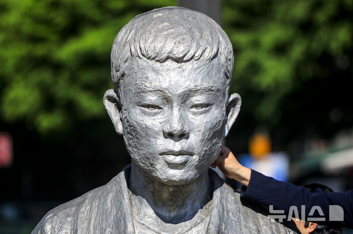 [서울=뉴시스] 정병혁 기자 = 노동절을 하루 앞둔 30일 서울 종로구 전태일다리를 찾은 시민들이 전태일 동상을 닦고 있다. 2026.04.30. jhope@newsis.com