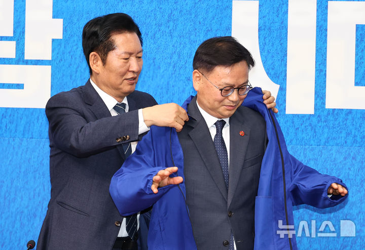 [서울=뉴시스] 김금보 기자 = 정청래 더불어민주당 대표가 30일 오전 서울 여의도 국회에서 열린 3차 인재영입식에서 김성범 전 해양수산부 차관에게 당점퍼를 입혀주고 있다. 2026.04.30. kgb@newsis.com