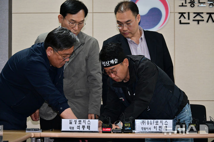 [진주=뉴시스] 차용현 기자 = 민주노총 공공운수노조 화물연대본부와 BGF로지스는 30일 오전 경남 진주시 고용노동부 진주지청에서 조인식을 열고 교섭을 통해 마련된 단체합의서에 서명했다. 사진은 화물연대 김동국 위원장이 합의서에 서명을 하고 있다. 2026.04.30. con@newsis.com