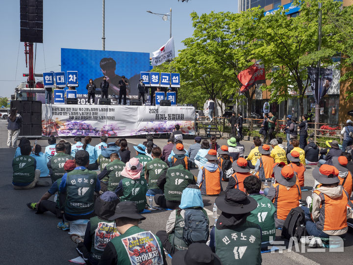 [전주=뉴시스] 강경호 기자 = 1일 전북 전주시 완산구 효자동 전북도청 사거리에서 진행된 2026 세계 노동절 대회에서 무대에 오른 전국금속노조 현대글로비스전주지회의 발언을 대회에 참석한 이들이 청취하고 있다. 2026.05.01. lukekang@newsis.com