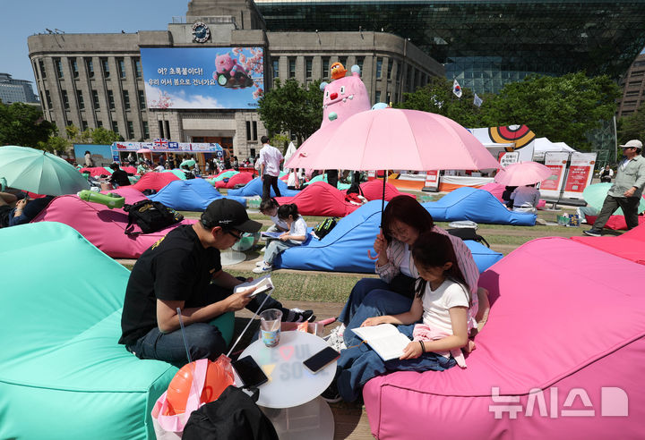 [서울=뉴시스] 조수정 기자 = 1일 서울 중구 서울광장에서 개장한 '책 읽는 서울광장'에서 한 가족이 독서를 즐기고 있다. 2026.05.01. chocrystal@newsis.com