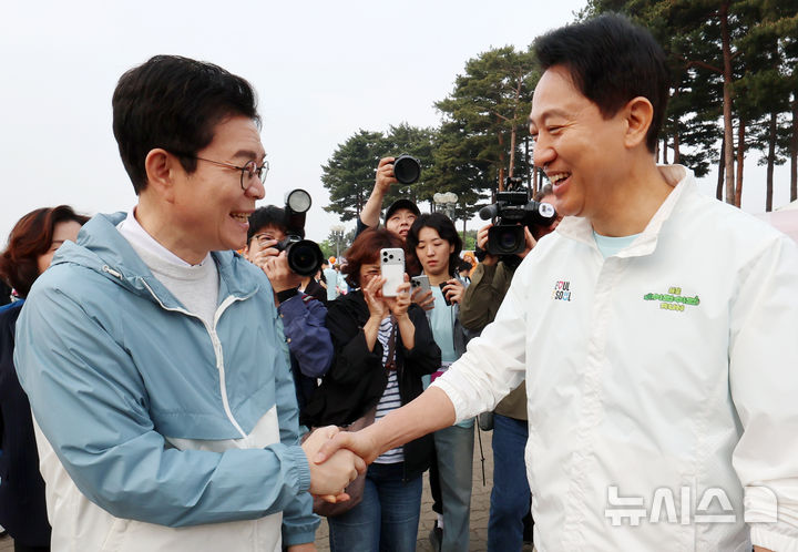 [서울=뉴시스] 조성우 기자 = 정원오(왼쪽) 더불어민주당 서울시장 후보와 오세훈 국민의힘 서울시장 후보가 2일 오전 서울 마포구 평화의공원 평화광장에서 열린 제26회 여성마라톤 대회에서 악수하고 있다. 2026.05.02. xconfind@newsis.com