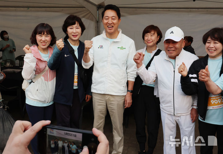 [서울=뉴시스] 조성우 기자 = 오세훈 국민의힘 서울시장 후보가 2일 오전 서울 마포구 평화의공원 평화광장에서 열린 제26회 여성마라톤 대회에서 참석자들과 기념촬영하고 있다. 2026.05.02. xconfind@newsis.com
