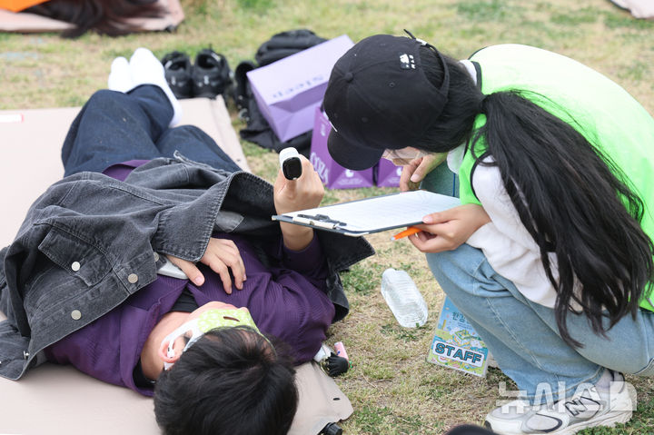 [서울=뉴시스] 권창회 기자 = 2일 서울 영등포구 여의도 한강공원에서 열린 ‘2026 한강 잠퍼자기 대회’에서 스태프가 참가자의 손가락 맥박을 재고 있다. 2026.05.02. kch0523@newsis.com