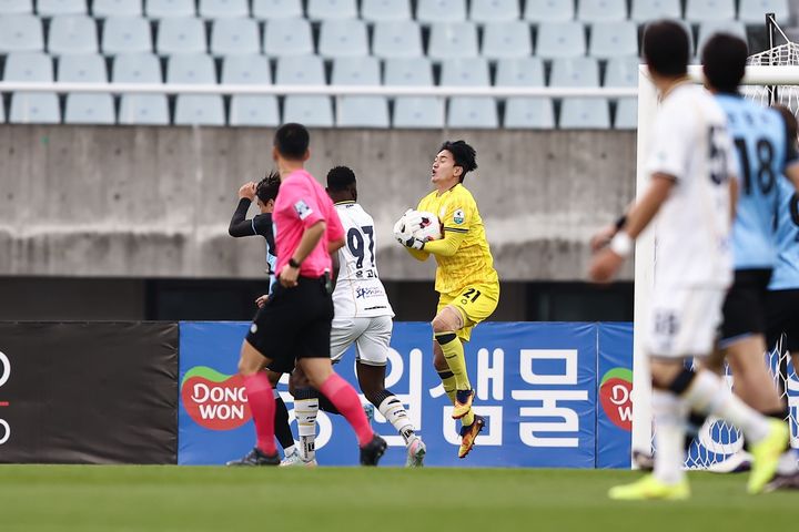 [천안=뉴시스] 천안시티FC 박대한(노란 유니폼)이 3일 충남아산FC와의 경기 중 공을 잡으려 하고 있다. 2026.05.03 (사진=충남아산FC 제공) 2026.05.03 photo@newsis.com *재판매 및 DB 금지