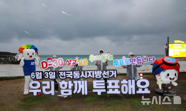 [제주=뉴시스] 우장호 기자 = 6·3 지방선거가 30일 남은 3일 오전 제주시 조천읍 함덕해수욕장 내에 설치된 지방선거 홍보 조형물 앞에서 제주도선거관리위원회 관계자들이 도민과 관광객을 대상으로 투표참여를 독려하는 피켓팅 퍼포먼스를 하고 있다. 2026.05.03. woo1223@newsis.com