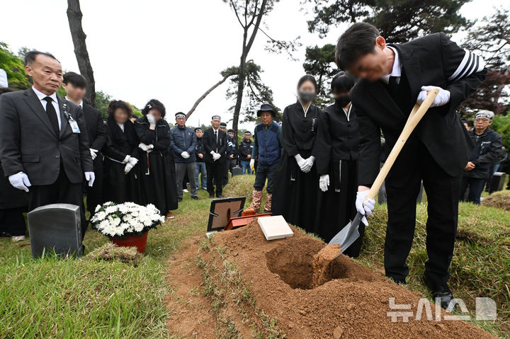 [광주=뉴시스] 이영주 기자 = 3일 오후 광주 북구 망월동 5·18구묘역 내 민족민주열사묘역에서 경남 진주 집회 참여 도중 화물차에 치어 숨진 화물연대 조합원 고(故) 서모씨의 하관식이 진행되고 있다. 2026.05.03. leeyj2578@newsis.com