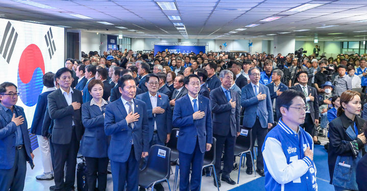 [서울=뉴시스] 고승민 기자 = 더불어민주당 정청래 대표와 김경수 경남도지사 후보 등 참석자들이 3일 경남 창원 김경수 경남도지사 선거사무소에서 열린 개소식에서 국민의례를 하고 있다. (사진=더불어민주당 제공) 2026.05.03. photo@newsis.com *재판매 및 DB 금지