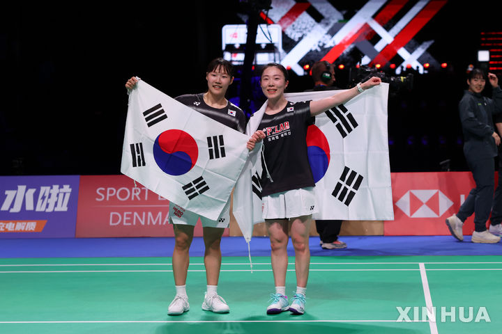 [호르센스=신화/뉴시스] 백하나(왼쪽)와 김혜정이 3일(현지 시간) 덴마크 호르센스에서 열린 2026 세계여자단체배드민턴선수권대회(우버컵) 중국과 결승 4경기 복식에서 자이판-장수셴 조를 물리친 후 태극기를 두른 채 기뻐하고 있다. 백하나-김혜정 조가 2-1(16-21 21-10 21-3)로 역전승을 거뒀고, 한국은 중국을 3-1로 꺾으며 통산 세 번째 우승을 차지했다. 2026.05.04.