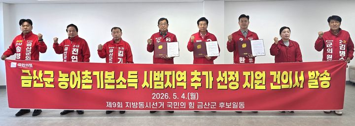 [금산=뉴시스] 조명휘 기자 = 박범인(오른쪽 네번째) 국민의힘 금산군수 후보와 지방의원 출마자들이 4일 군수후보 선거사무소에서 '농어촌 기본소득 시범지역 추가 선정 건의서'에 서명한 뒤 충남도지사, 지역 국회의원, 농림축산식품부 장관에게 발송하고 있다. (사진= 박 후보 선대위 제공) 2026.05.04. photo@newsis.com *재판매 및 DB 금지
