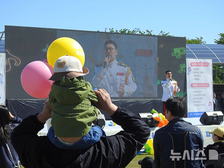 [제주=뉴시스] 김수환 기자 = 5일 오전 제주시 오라동 애향운동장에서 열린 제104회 어린이날 기념 행사에서 한 어린이가 보호자와 공연을 관람하고 있다. 2026.05.05. notedsh@newsis.com