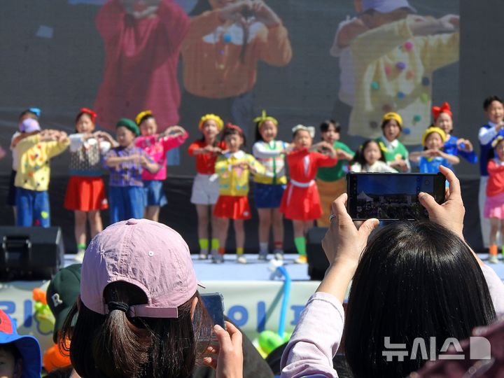 [제주=뉴시스] 김수환 기자 = 5일 오전 제주시 오라동 애향운동장에서 열린 제104회 어린이날 기념 행사에서 클럽 노래하자춤추자(자자) 소속 어린이들이 준비한 공연을 선보이고 있는 가운데 보호자들이 자녀의 모습을 기록하고 있다. 2026.05.05. notedsh@newsis.com