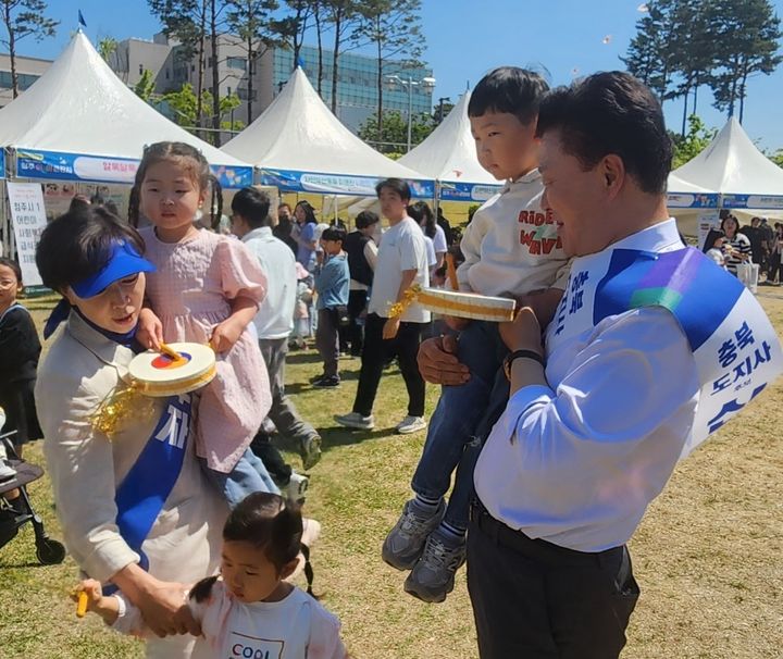 [청주=뉴시스] 신용한 더불어민주당 후보가 어린이날인 5일 청주시 청원구 주중동 생명누리공원에서 배우자와 함께 나들이 나온 아이들과 대화하고 있다. (사진=신용한 후보 캠프 제공) *재판매 및 DB 금지
