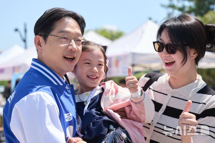 [김해=뉴시스]더불어민주당 김경수 경남도지사 후보가 제104회 어린이날인 5일 오전 김해 장유 롯데가든파크에서서 열린 김해 꿈나무 어린이날 큰잔치에 엄마와 참석한 어린이를 안고 기념촬영하고 있다.(사진=김경수후보 선거사무소 제공) 2026.05.05. photo@newsis.com