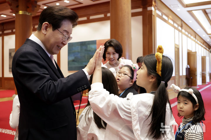 [서울=뉴시스] 최동준 기자 = 이재명 대통령과 김혜경 여사가 5일 청와대에서 열린 '2026년 제104회 어린이날 청와대 초청행사'에서 어린이들과 인사하고 있다. 2026.05.05. photocdj@newsis.com