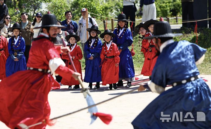 [서울=뉴시스] 김명년 기자 = 어린이날인 5일 오전 서울 종로구 경복궁 협생문에서 열린 갑사 취재 체험에서 전통 군복인 철릭을 입은 어린이들이 무예 공연을 관람하고 있다. 갑사 취재는 조선시대 궁궐 경비와 국왕 호위를 전담했던 중앙군 최정예 특수부대인 '갑사'를 선발하는 실기 평가다. 2026.05.05. kmn@newsis.com