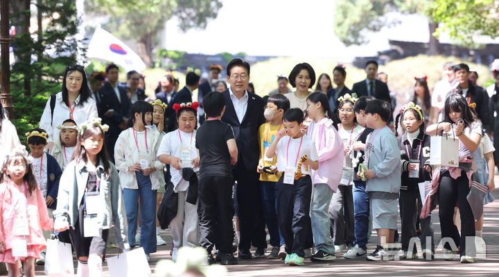 [서울=뉴시스] 최동준 기자= 이재명 대통령과 김혜경 여사가 5일 청와대에서 열린 2026 어린이날 초청행사에 참석한 어린이들과 녹지원으로 이동하고 있다. 2026.05.05. photocdj@newsis.com