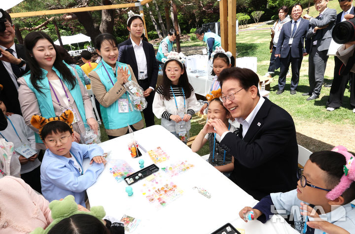 [서울=뉴시스] 최동준 기자= 이재명 대통령이 5일 청와대 녹지원에서 열린 2026 어린이날 초청행사에 참석한 어린이들과 나만의 키캡 만들기 체험을 하고 있다. 2026.05.05. photocdj@newsis.com