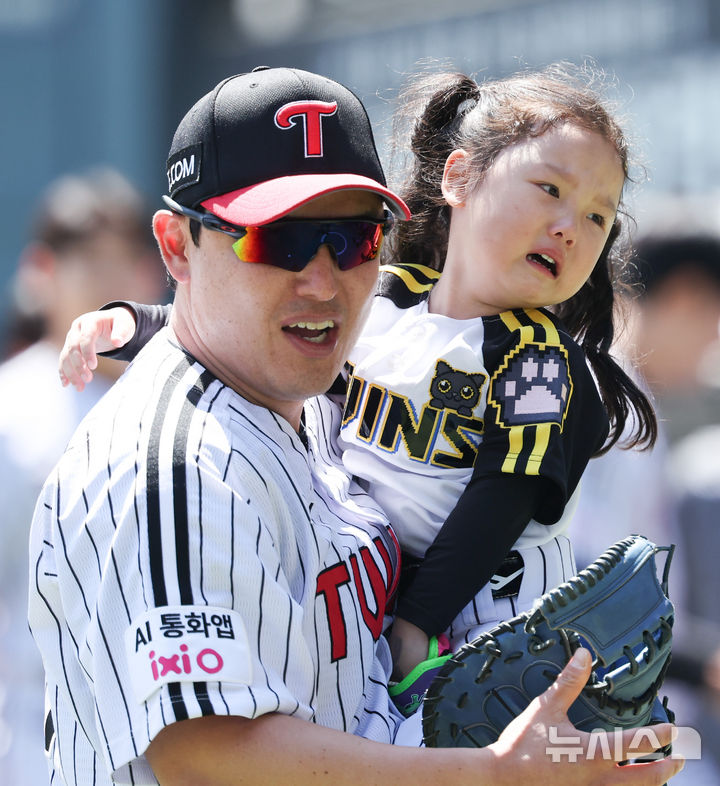 [서울=뉴시스] 최진석 기자 = 5일 서울 송파구 잠실야구장에서 열린 2026 KBO리그 두산 베어스와 LG 트윈스의 경기에서 LG 박동원과 딸 박채이 양이 시구 후 이동하고 있다. 2026.05.05. myjs@newsis.com
