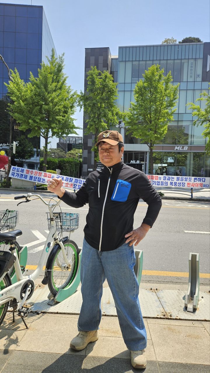 [서울=뉴시스] 남주현 기자 = 경기 용인 신갈에서 온 '주주행동 실천본부'의 한 주주가 서울 용산구 이태원로 현수막 시위 앞에서 발언하고 있다. 2025.05.06. *재판매 및 DB 금지