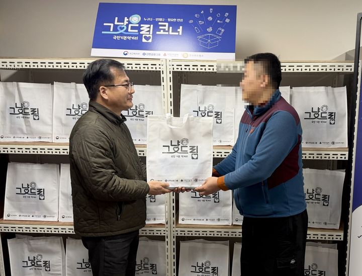 [태안=뉴시스] 최근 충남 태안군 푸드뱅크를 찾은 한 군민이 관계자로부터 '그냥드림' 꾸러미를 받고 있다. (사진=태안군 제공) 202605.06. photo@newsis.com *재판매 및 DB 금지