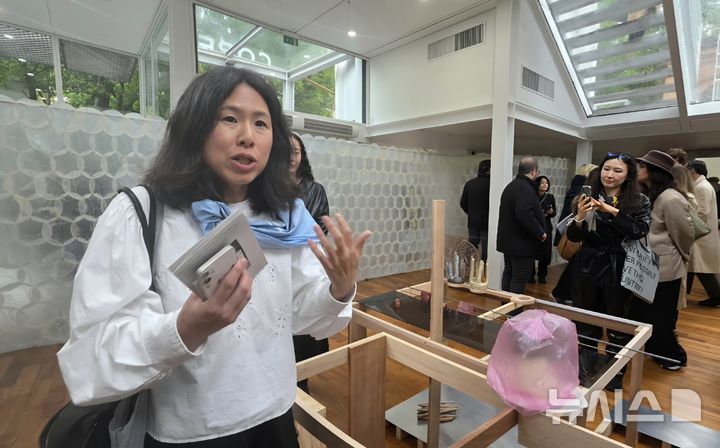 [베니스=뉴시스] 사진=박현주미술전문기자 =(현지시간) 이탈리아 베네치아 자르디니에서 개막한 제61회 베니스비엔날레 한국관 ‘해방공간: 요새와 둥지’ 전시장에서 최빛나 예술감독이 작품을 설명하고 있다. 이번 한국관은 해방 이후 한국 사회의 균열과 공존, 돌봄과 생존의 감각을 ‘요새’와 ‘둥지’라는 이중적 은유로 풀어낸다. 2026.05.06. hyun@newsis.