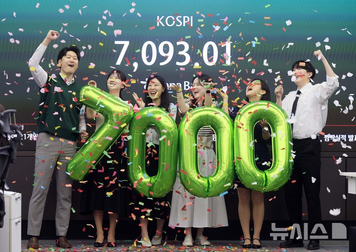 [서울=뉴시스] 정병혁 기자 = 코스피가 7000을 돌파한 6일 서울 중구 하나은행 딜링룸에서 직원들이 7000 돌파 세리머니를 하고 있다. 2026.05.06. jhope@newsis.com