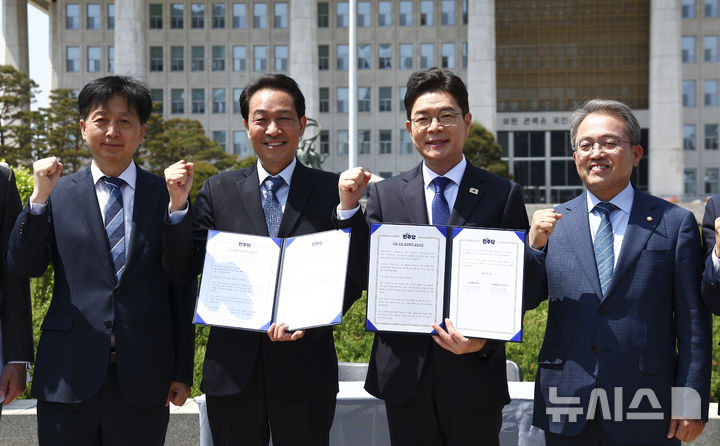 [서울=뉴시스] 김근수 기자 = 정원오 더불어민주당 서울시장 후보와 우상호 더불어민주당 강원도지사 후보가 6일 서울 여의도 국회 분수대 앞에서 열린 서울시장-강원도지사 후보 정책협약식에서 협약서를 들고 기념촬영을 하고 있다. 2026.05.06. ks@newsis.com