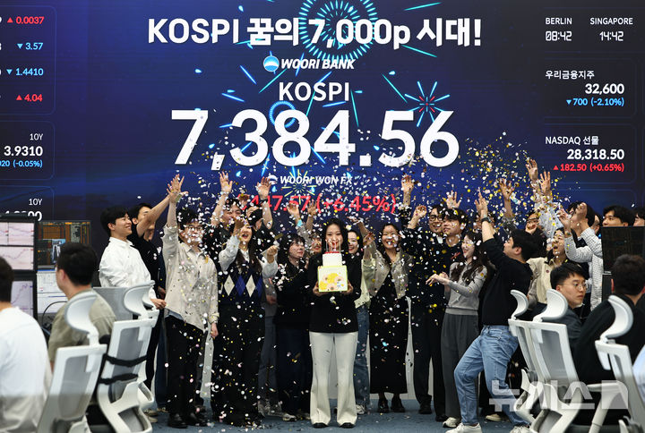 [서울=뉴시스] 김명년 기자 = 코스피가 7384.56으로 사상 최대치 마감한 6일 오후 서울 중구 우리은행 딜링룸에서 직원들이 축하 세리머니를 하고 있다. 2026.05.06. kmn@newsis.com