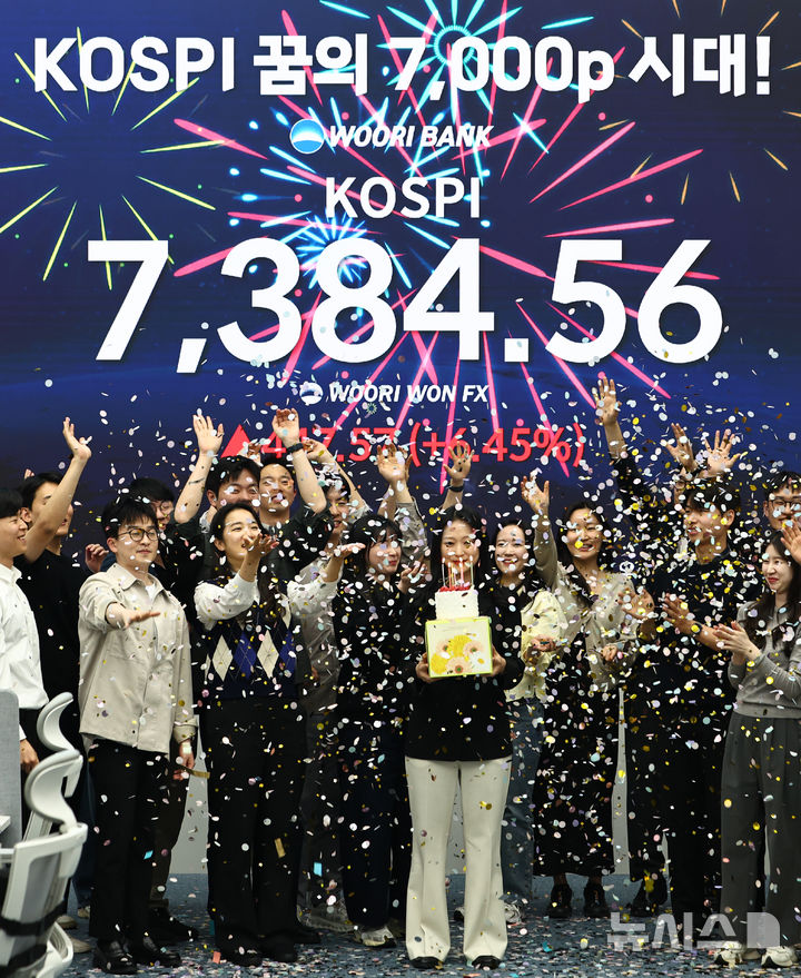 [서울=뉴시스] 김명년 기자 = 코스피가 7384.56으로 사상 최대치 마감한 6일 오후 서울 중구 우리은행 딜링룸에서 직원들이 축하 세리머니를 하고 있다. 2026.05.06. kmn@newsis.com
