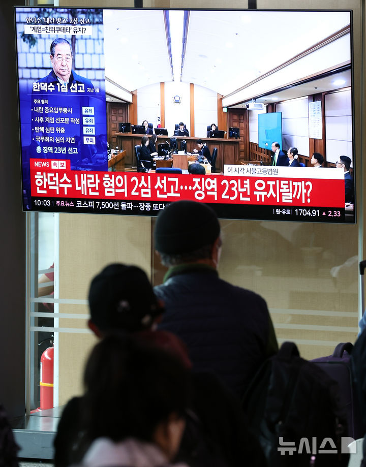 [서울=뉴시스] 최진석 기자 = 12·3 비상계엄 사태와 관련해 내란 중요임무 종사 등 혐의로 기소된 한덕수 전 국무총리의 2심 선고일인 7일 서울역 대합실에서 시민들이 선고 공판 방송을 지켜보고 있다. 2026.05.07. myjs@newsis.com