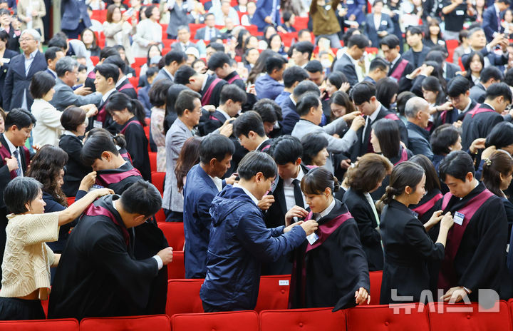 [과천=뉴시스] 황준선 기자 = 7일 오전 경기 과천시 정부과천청사 대강당에서 열린 신임 검사 임관식에서 가족들이 신임 검사에게 법복을 입혀주고 있다. 2026.05.07. hwang@newsis.com
