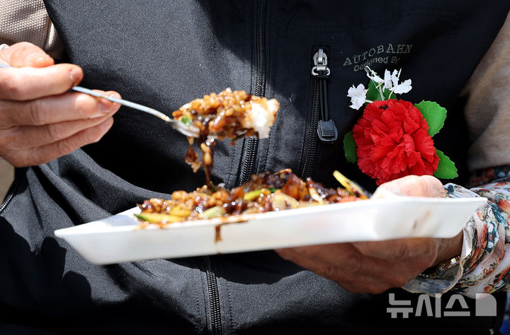 [대구=뉴시스] 이무열 기자 = 어버이날을 하루 앞둔 7일 대구 달서구 두류공원 사랑해밥차 무료급식소에서 자원봉사자들이 선물한 카네이션을 가슴에 달고 어르신들이 점심 식사를 하고 있다. 2026.05.07. lmy@newsis.com