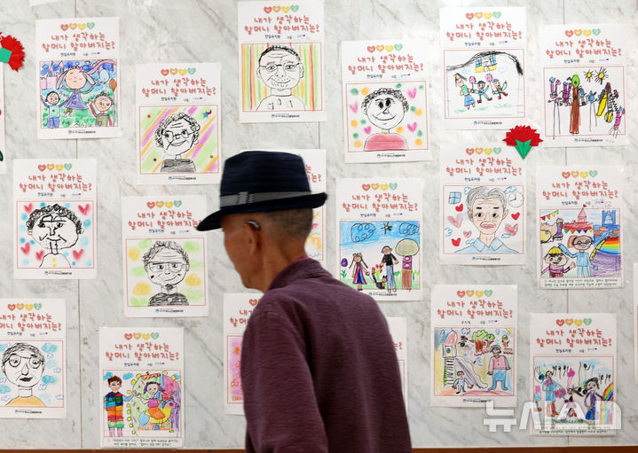 [서울=뉴시스] 최진석 기자 = 7일 서울 중구구민회관에서 열린 '오월애(愛) 어버이 꽃길을 걷다' 행사를 찾은 어르신이 유치원생들이 그린 내가 사랑하는 할머니, 할아버지 그림 앞을 지나고 있다. 2026.05.07. myjs@newsis.com