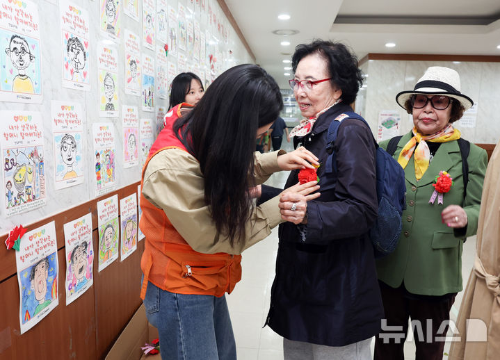 [서울=뉴시스] 최진석 기자 = 7일 서울 중구구민회관에서 열린 '오월애(愛) 어버이 꽃길을 걷다' 행사를 찾은 어르신이 카네이션을 옷에 달고 있는 모습. 2026.05.07. myjs@newsis.com