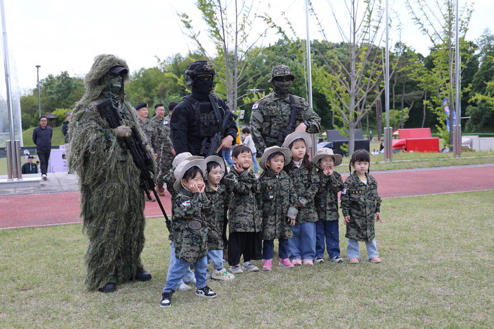 [여주=뉴시스] 특전사 주둔지를 방문한 어린이들이 길리슈트를 착용한 특전대원들과 기념사진을 촬영하고 있다. (사진=육군 특수전사령부 제공) 2026.05.08. photo@newsis.com *재판매 및 DB 금지