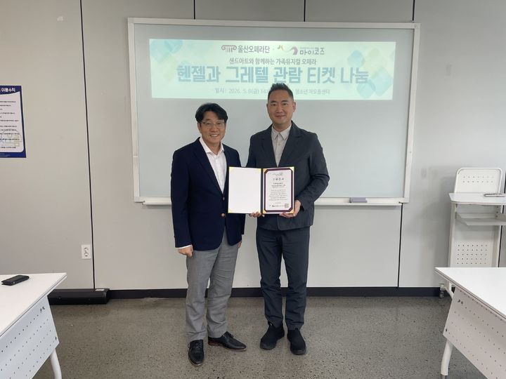 [울산=뉴시스] 8일 울산문화예술 대공연장에서 울산오페라단 천영진 대표가 마이코즈 예동열 이사장에게 청소년들을 위한 가족뮤지컬 오페라 '헨젤과 그레텔' 공연 관람 티켓을 전달하고 있다. (사진=마이코즈 제공) 2026.05.08. photo@newsis.com *재판매 및 DB 금지